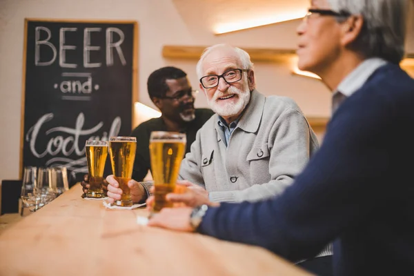 Amigos mayores bebiendo cerveza juntos - foto de stock