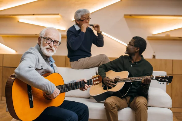 Amis aînés jouant de la musique — Photo de stock