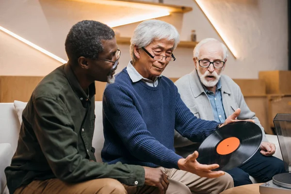 Amigos mayores con disco de vinilo - foto de stock