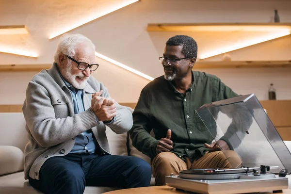 Senior friends listening vinyl record — Stock Photo