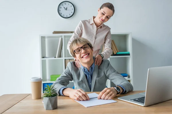 Woman massaging shoulders to colleague — Stock Photo