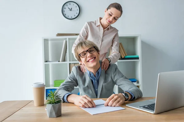 Donna massaggiare le spalle al collega — Foto stock