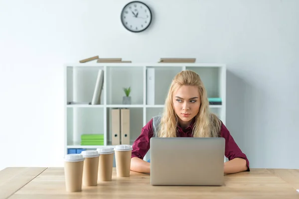 Angry woman sitting at laptop — Stock Photo