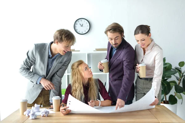 Business partners looking at flipchart paper — Stock Photo