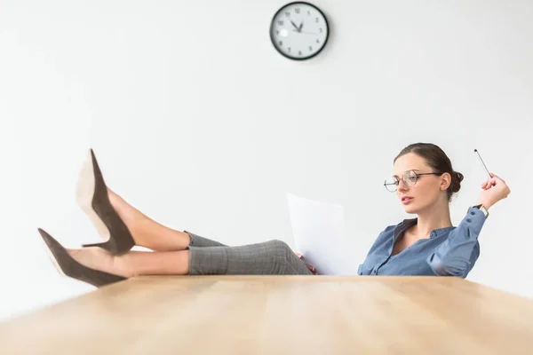 Geschäftsfrau sitzt mit Beinen auf Tisch — Stockfoto