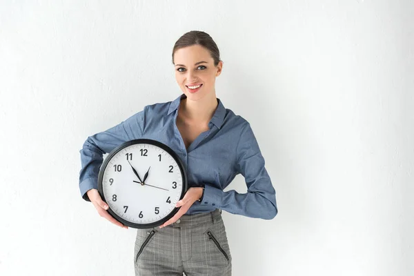 Businesswoman holding wall clock in hands — Stock Photo