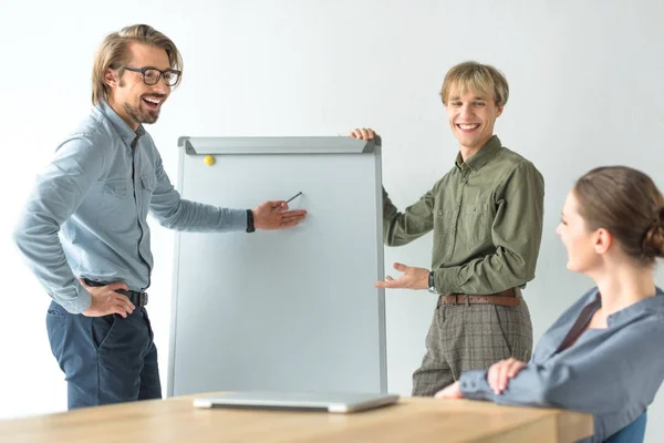 Uomini d'affari che mostrano qualcosa su flipchat — Foto stock