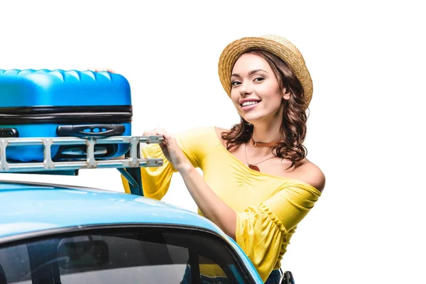 Mujer poniendo equipaje en el techo del coche - foto de stock