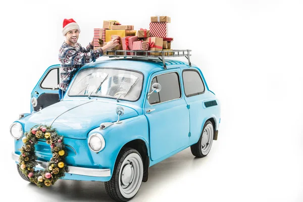 Hombre wiith regalos de Navidad en el techo del coche - foto de stock