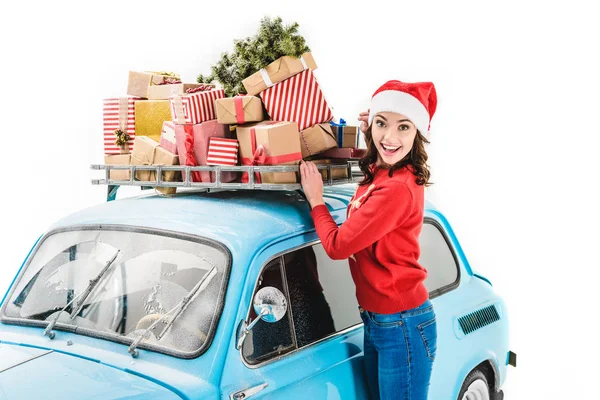Woman with christmas gifts on car roof — Stock Photo