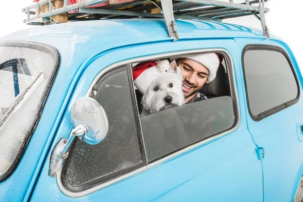 Мужчина в машине с собакой и рождественскими подарками — стоковое фото