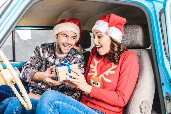 Mann teilt Weihnachtsgeschenk an Frau — Stockfoto