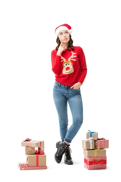 Mujer reflexiva con regalos de Navidad - foto de stock