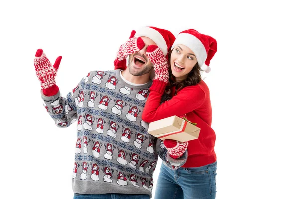 Woman closing eyes to man with christmas gift — Stock Photo