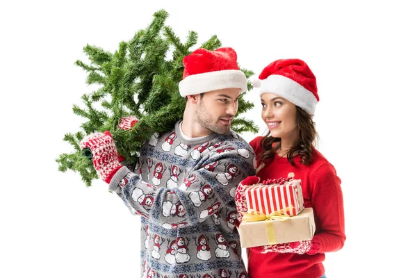 Pareja llevando árbol de navidad y regalos - foto de stock