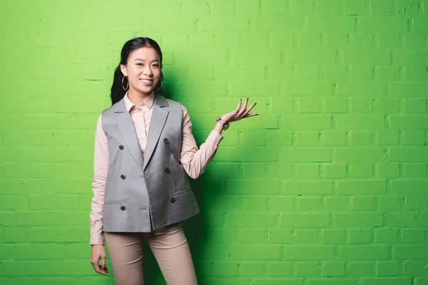Asiática mujer de negocios presentando algo - foto de stock