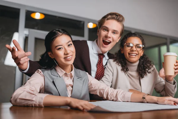 Excité entrepreneurs multiculturels avec café et documents de travail dans le bureau — Photo de stock