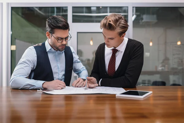 Uomini d'affari che lavorano insieme con il progetto e tablet in ufficio — Foto stock