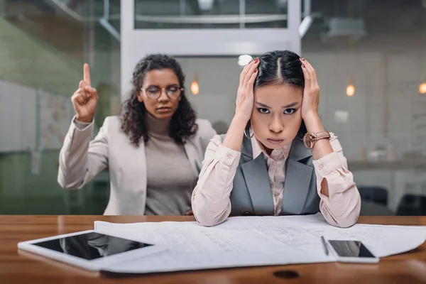 Gestresste multiethnische Geschäftsfrauen, die im Amt mit Dokumenten arbeiten — Stockfoto