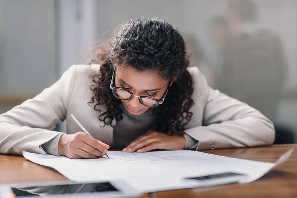 Femme d'affaires afro-américaine faisant de la paperasserie au bureau — Photo de stock