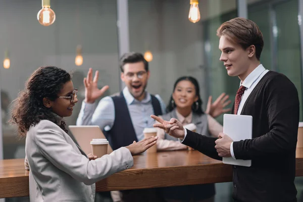 Happy multiethnic business team playing rock paper scissors — Stock Photo