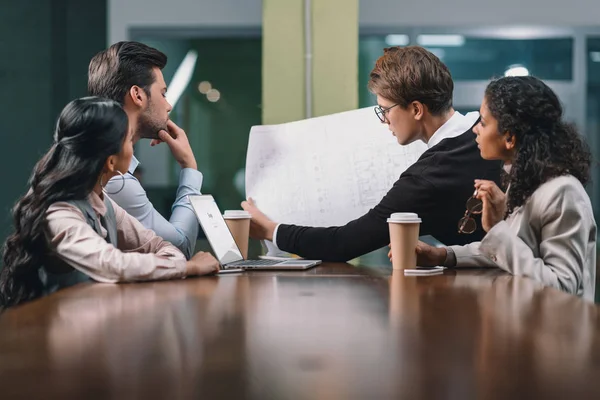 Multiethnic business team working with blueprint on meeting — Stock Photo
