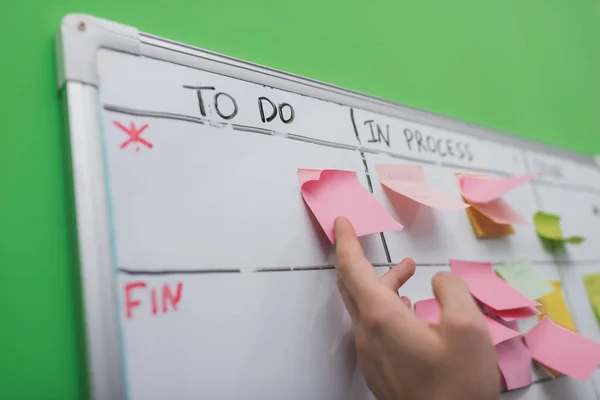 Cropped view of businessman puting sticky note on task board — Stock Photo