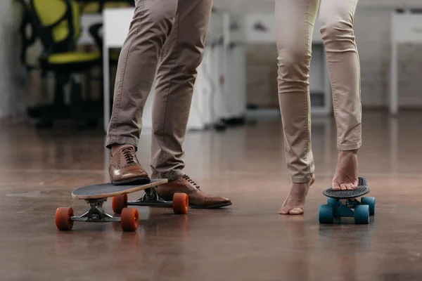 Visão cortada de empresários se divertir com skates no escritório — Fotografia de Stock