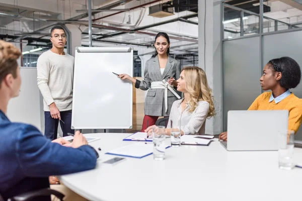 Group of young managers making presentation for boss at conference hall — Stock Photo