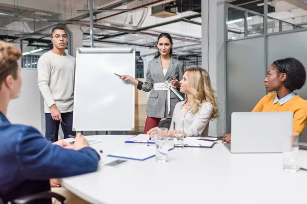 Groupe de jeunes gestionnaires faisant une présentation pour le patron à la salle de conférence — Photo de stock