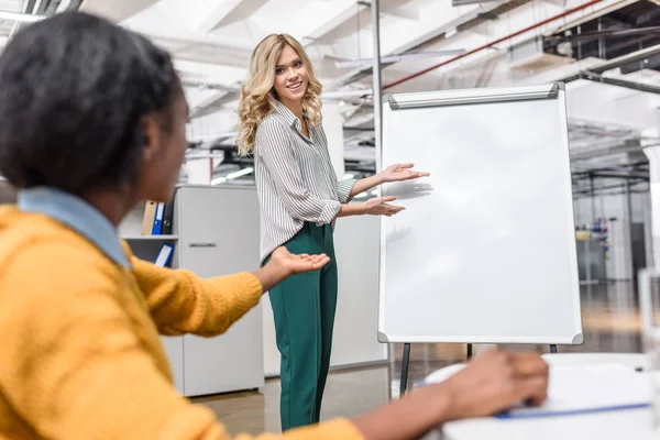 Giovane manager makig presentazione con lavagna bianca per la sua collega — Foto stock
