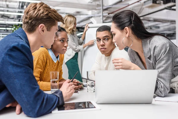 Jóvenes gerentes multiétnicos que trabajan juntos en la sala de conferencias - foto de stock