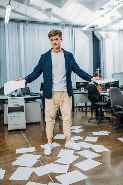 Homme d'affaires au bureau avec des papiers vierges sur le sol autour de lui — Photo de stock