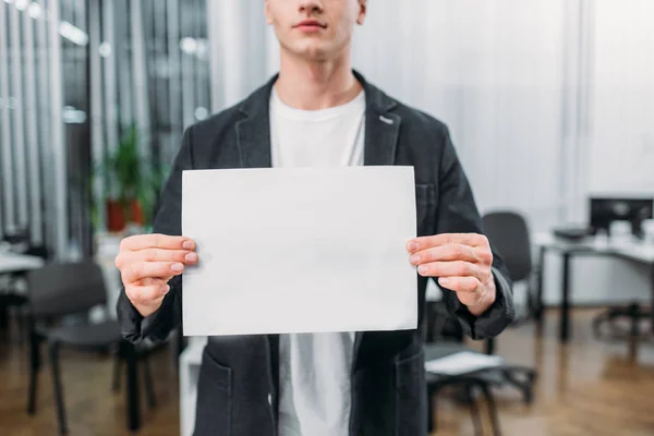 Cropped shot of young man holding blank paper — Stock Photo