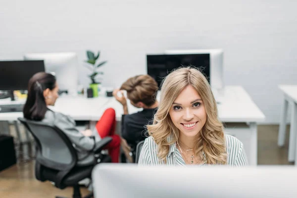 Joven hermosa mujer que trabaja con la computadora en la oficina moderna - foto de stock