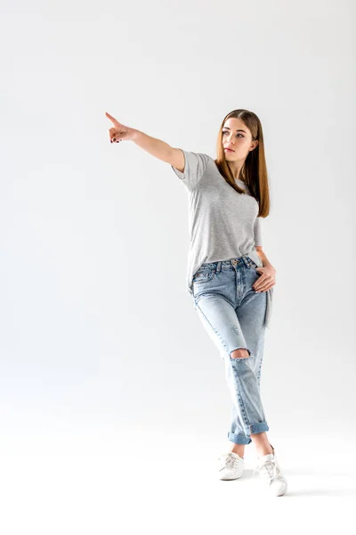 Attraente giovane donna che punta e distoglie lo sguardo, isolato sul bianco — Foto stock