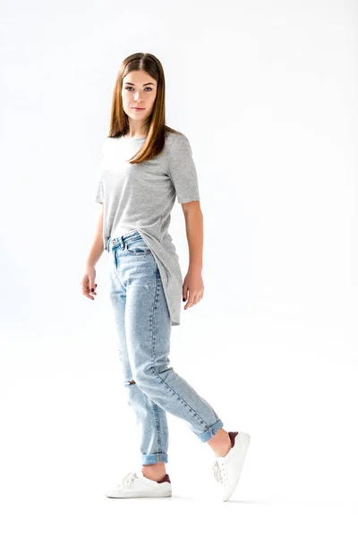 Young stylish woman in jeans and grey shirt looking at camera,  isolated on white — Stock Photo