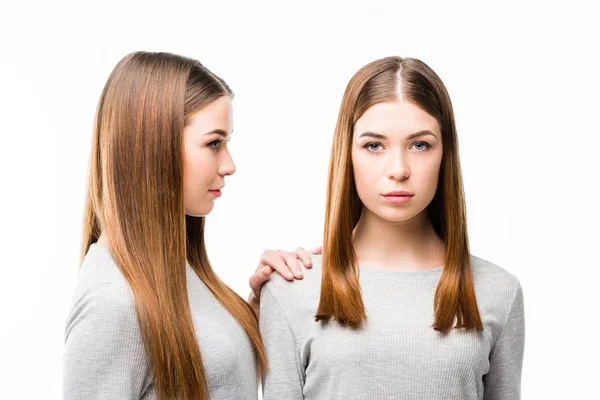 Portrait of attractive pensive twins in grey tshirts isolated on white — Stock Photo