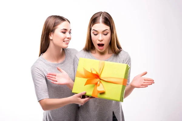 Retrato de mujer sonriente sorprendente hermana gemela con presente - foto de stock