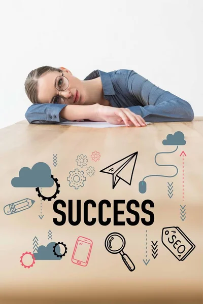 Empresária cansada deitada à mesa no escritório com inscrições de sucesso e ícones de negócios — Fotografia de Stock