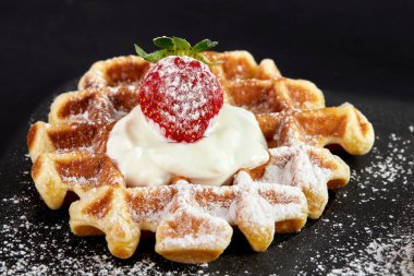 Çilekli Viyana waffle 'ı, siyah frenk üzümü, böğürtlen, üstüne çikolata, krema ve pudra şekeri..