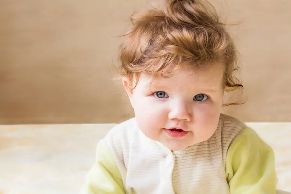 Mooie kleine baby zit en glimlachen. — Stockfoto