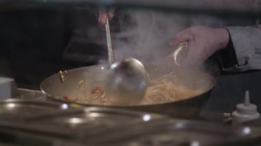 Şef tuzları ve savurma Fried sebze ile bir tavada et ticari mutfak pişirme