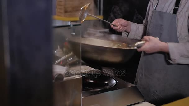 Cocinero revolviendo verduras fritas con carne en una sartén, cocina comercial — Vídeos de Stock