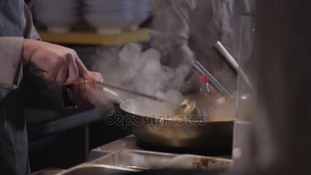 Szakács van keverés tészta, zöldség és hús a Wok: kereskedelmi konyha, pán-ázsiai ételeket — Stock videók