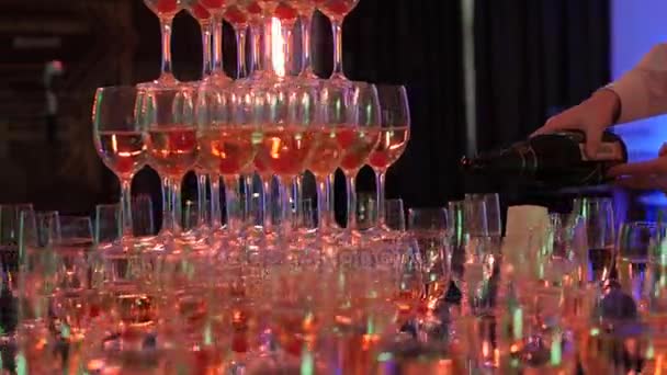Официант разливает шампанское в башню из бокалов, вечеринки и празднования, крупным планом — стоковое видео