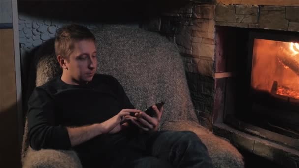 Porträtt av ung Man med tablett dator nära eldstaden — Stockvideo