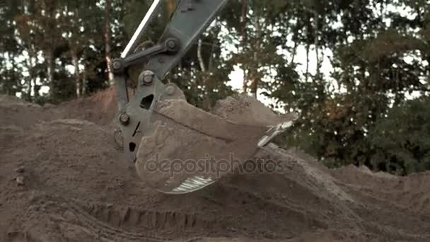 Excavadora excavación de arena y polvo de trabajo durante las obras de carretera, primer plano tiro de cubo de una máquina de excavación de movimiento de tierra — Vídeo de stock