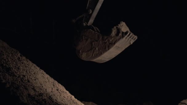 Bagger baggert Sand und Staub bei Straßenarbeiten in der Nacht aus, Nahaufnahme der Schaufel einer Erdbewegungsmaschine, Nachtarbeit, Überstunden — Stockvideo