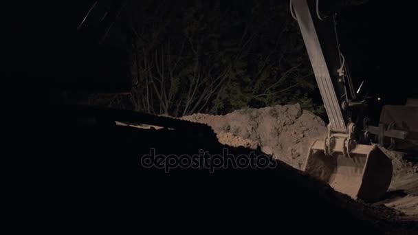 Graafmachine graven zand en stof werken tijdens wegwerkzaamheden bij nacht, close-up Shot van de emmer van een aarde-krachtbron graven Machine, nachtarbeid, overuren — Stockvideo